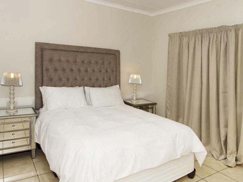 A well-maintained bedroom featuring neutral wall tones, tiled flooring, and decorative coving, providing a clean and comfortable living space.