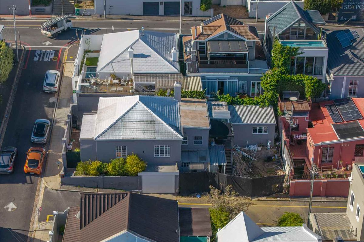 Aerial view of the property showing the roof structure, rear yard area, and surrounding street context in a dense urban residential neighborhood.