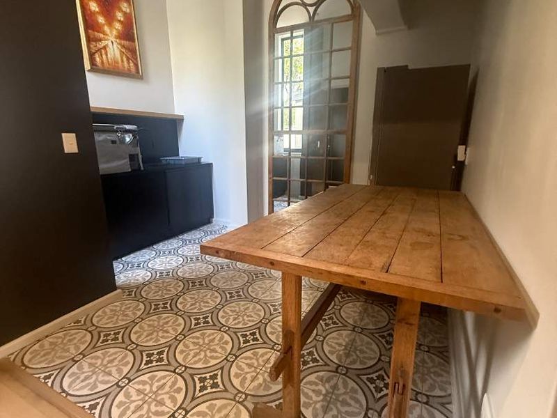 A kitchen area featuring decorative patterned floor tiles, built-in cabinetry, and an elegant arched glass door providing natural light.