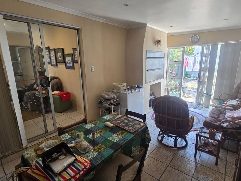 Open-plan living area featuring tiled flooring, a built-in fireplace, and sliding glass doors providing access to the rear outdoor space.