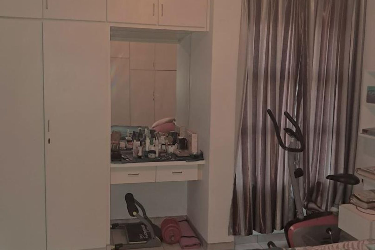 Bedroom featuring built-in floor-to-ceiling cabinetry with an integrated vanity station and tiled flooring.