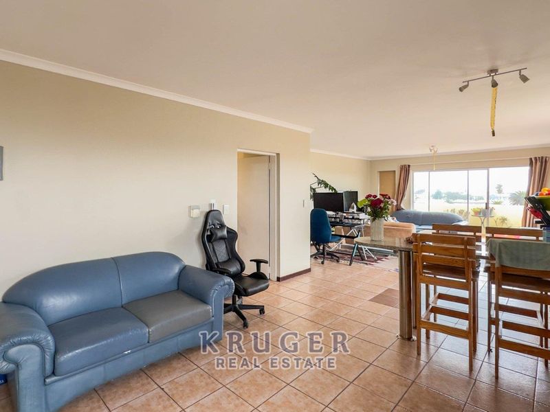 Spacious open-plan living and dining area featuring ceramic floor tiles and large sliding doors leading to an outdoor space.