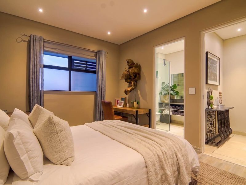 A well-maintained bedroom featuring recessed lighting, neutral wall tones, and direct access to an en-suite bathroom.