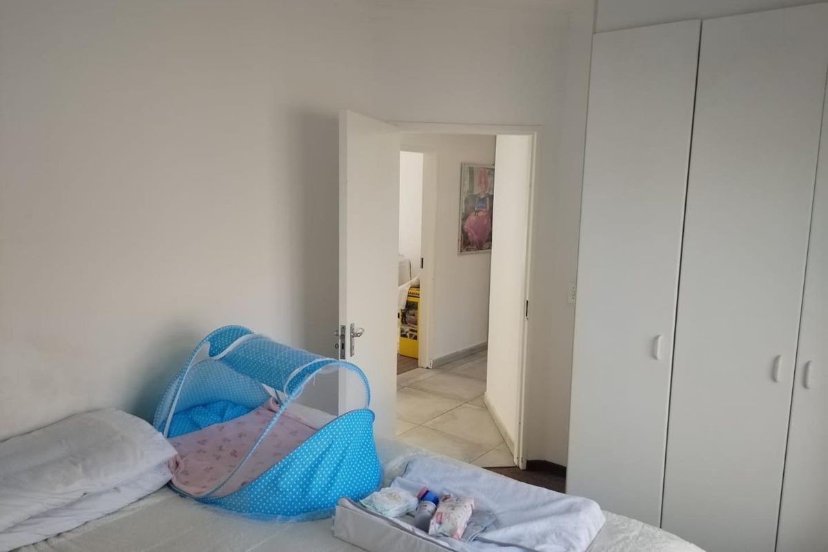A functional bedroom featuring built-in cupboards and direct access to an adjoining hallway.