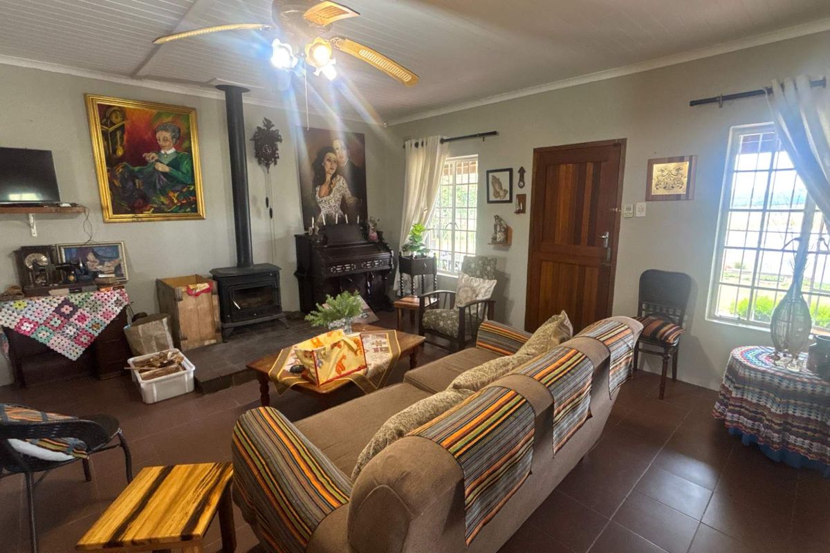 A cozy living room featuring a wood-burning stove, tiled flooring, and a ceiling fan, offering a warm and traditional atmosphere.