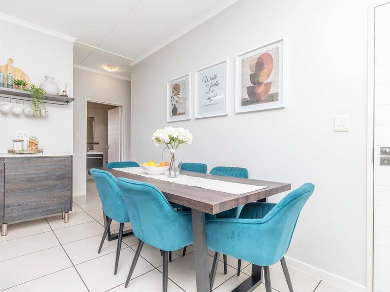 A bright and modern dining area featuring tiled flooring, neutral walls, and built-in cabinetry, creating a clean and functional space.