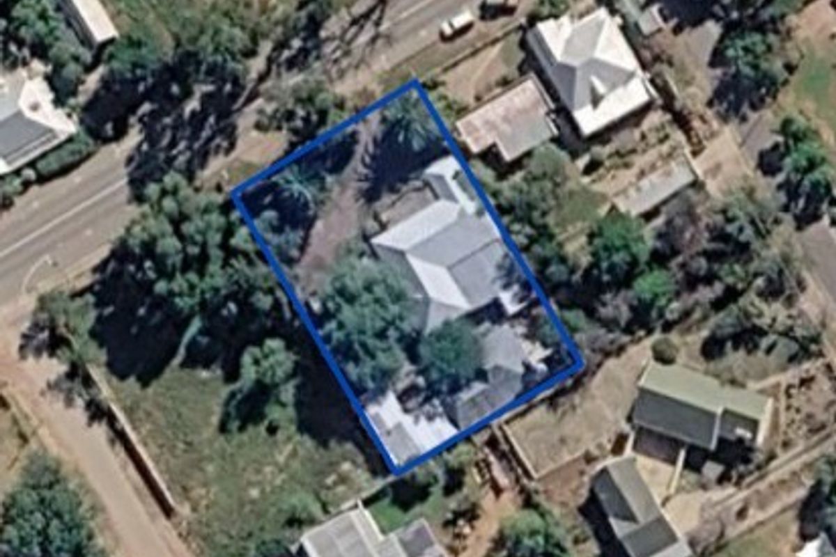 An aerial satellite view showing the property layout, roof structure, and surrounding grounds within the highlighted boundary.