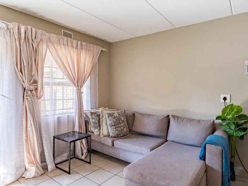 A living room featuring tiled flooring and a sliding glass door providing access to an outdoor area.