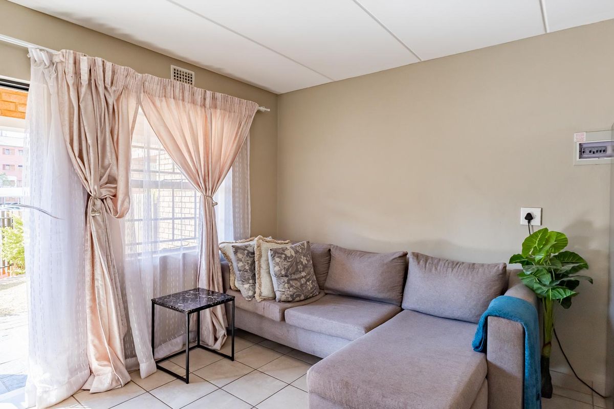 A living room featuring tiled flooring and a sliding glass door providing access to an outdoor area.