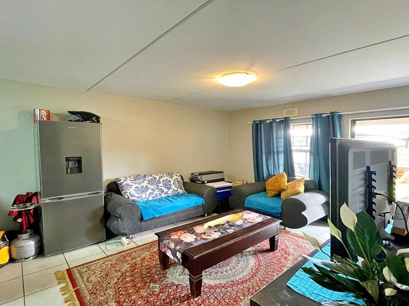 Open plan living area featuring tiled flooring and a sliding glass door providing access to the exterior.