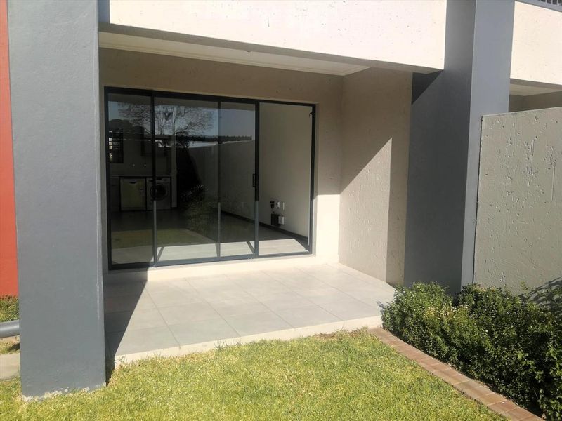 A covered patio area with tiled flooring and large sliding glass doors providing access to the interior living space.