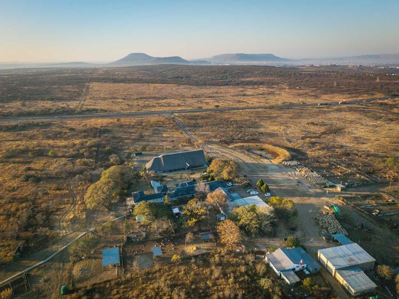 Aerial view of the guest house property featuring a large thatched roof main building, surrounding outbuildings, and expansive rural grounds.