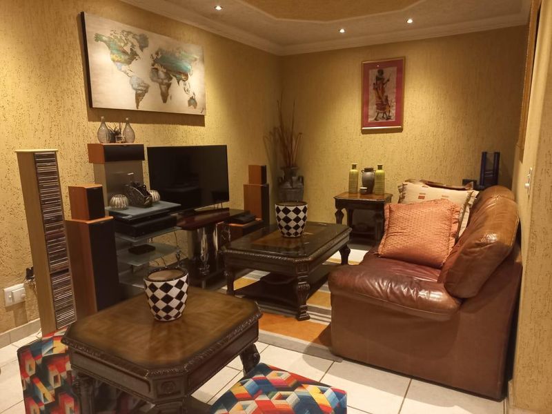 A cozy living room featuring textured walls, recessed downlighting, and tiled flooring, providing a warm and inviting atmosphere.