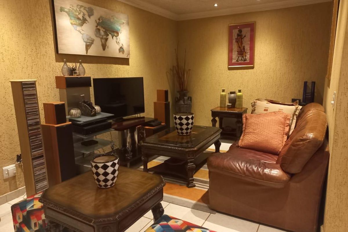 A cozy living room featuring textured walls, recessed downlighting, and tiled flooring, providing a warm and inviting atmosphere.