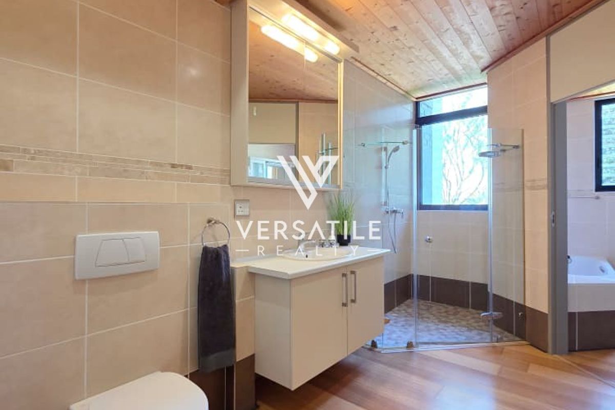Modern bathroom featuring a wall-hung toilet, vanity cabinet with mirror, and a glass-enclosed shower, complemented by a warm timber ceiling and tiled finishes.
