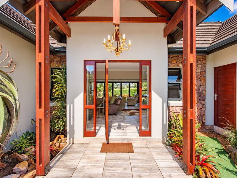 Inviting entrance featuring a timber-framed portico, stone cladding, and tiled flooring, providing a warm and architectural welcome to the home.