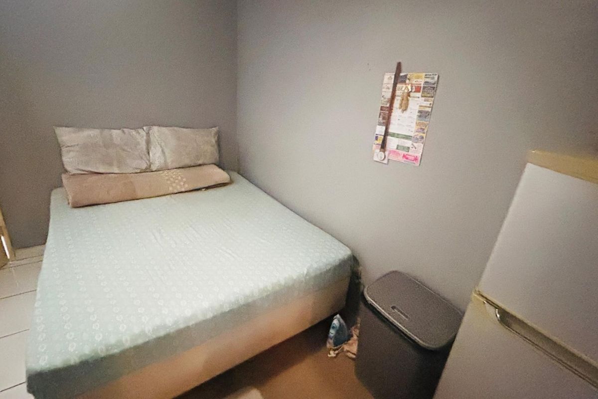 A compact bedroom featuring tiled flooring and neutral wall finishes, suitable for a single bed setup.