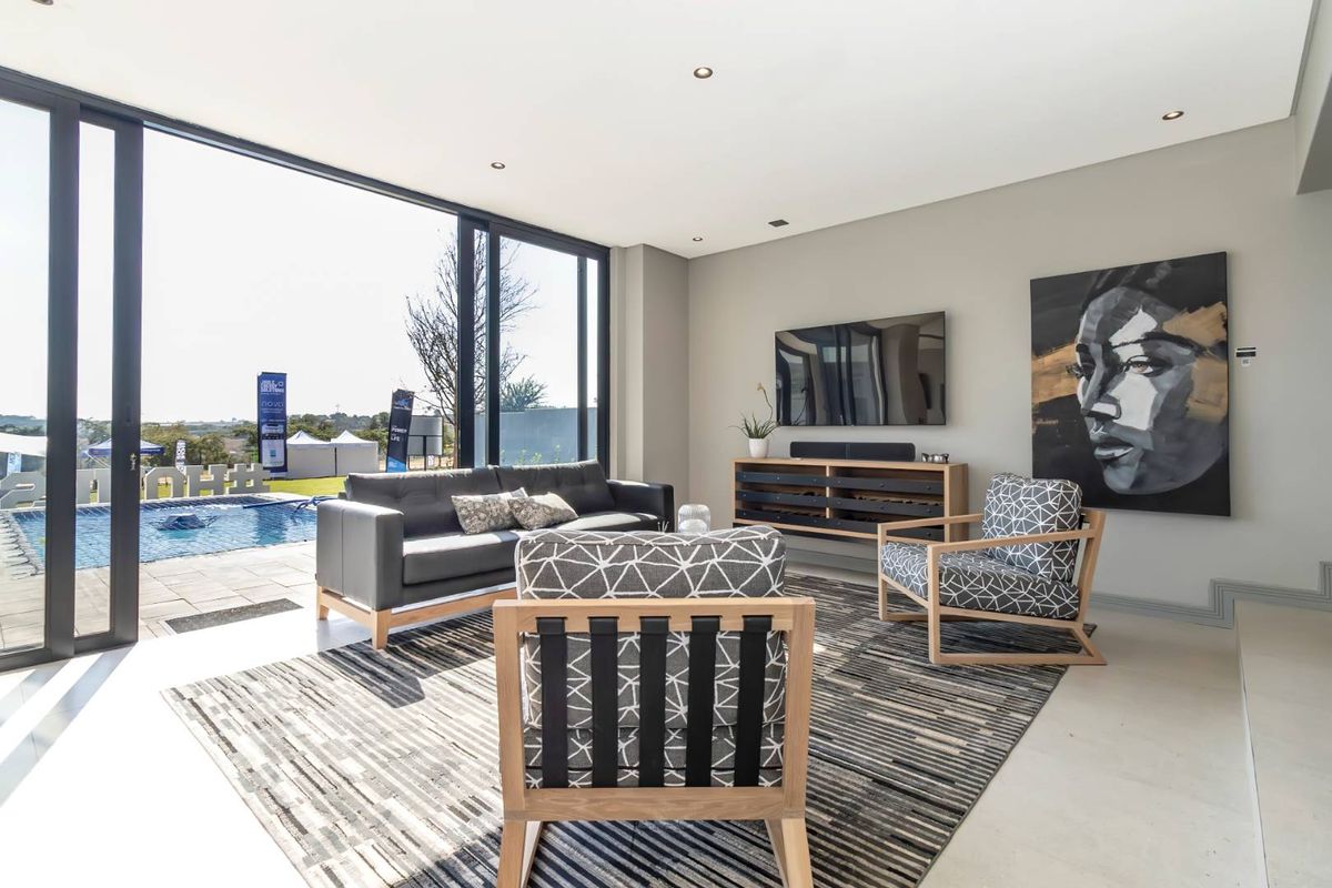 Modern open-plan living area featuring large floor-to-ceiling sliding glass doors that provide seamless indoor-outdoor flow to the pool deck.