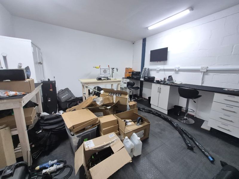 A functional industrial utility space featuring built-in workbenches, cabinetry, and durable rubberized flooring, suitable for workshop or storage use.