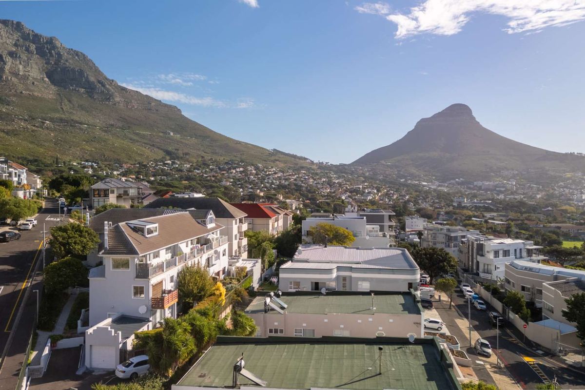 An elevated aerial view of the residential neighborhood, showcasing the surrounding urban landscape and mountain scenery.