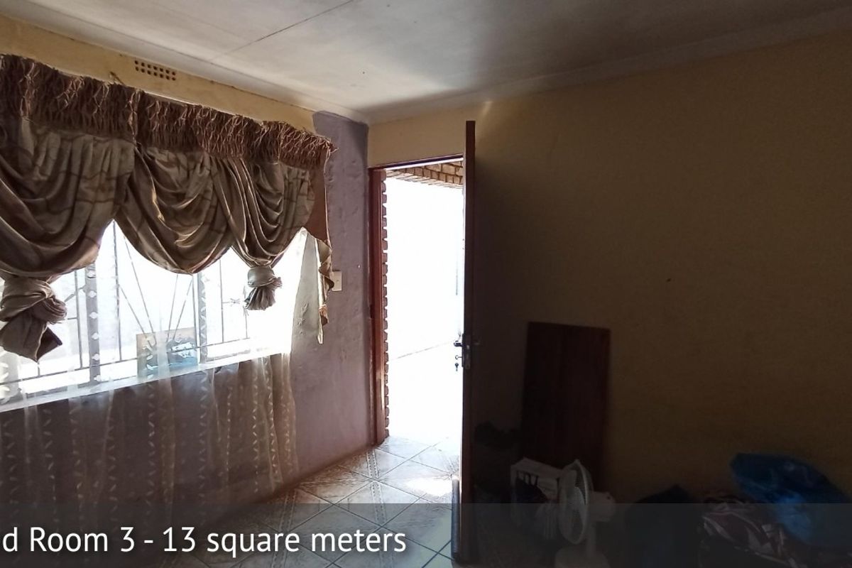 A bedroom featuring tiled flooring and security bars on the window, requiring cosmetic updates to the wall finishes.