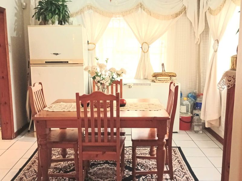 A dining area featuring tiled flooring and natural light, providing a functional space for family meals.