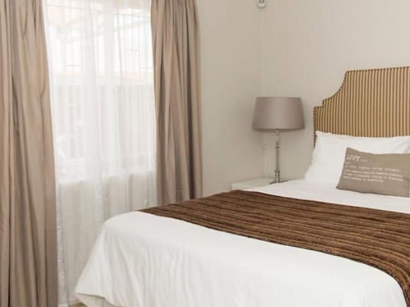 A well-maintained bedroom featuring neutral wall tones, tiled flooring, and classic cove cornicing, providing a clean and comfortable living space.