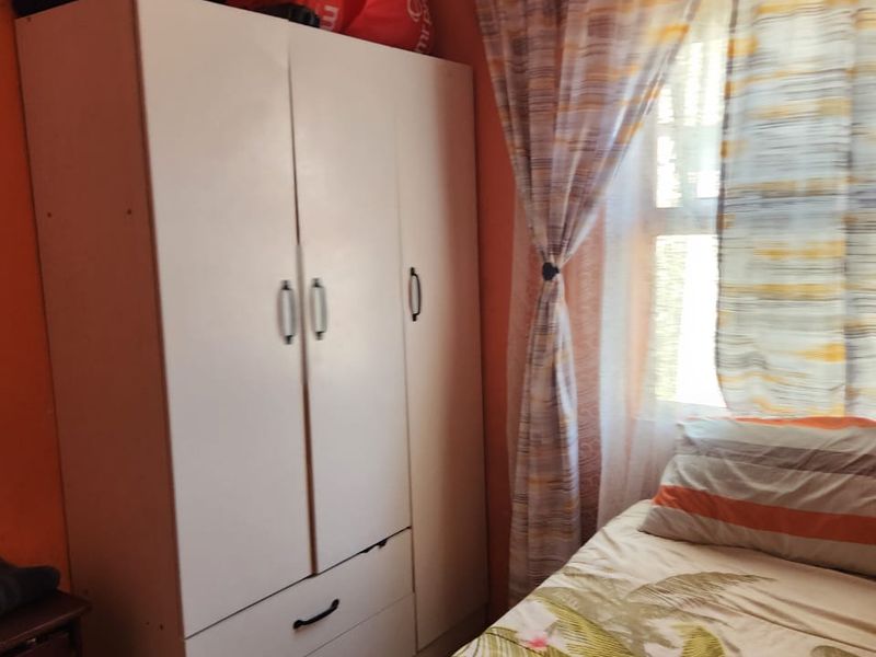 A bedroom featuring a built-in wardrobe and natural light from the window.