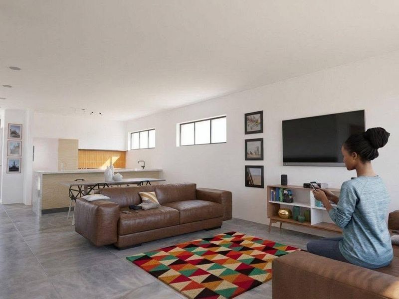 Spacious open-plan living area featuring modern tiled flooring, a functional kitchen island, and a seamless flow between the kitchen and lounge space.