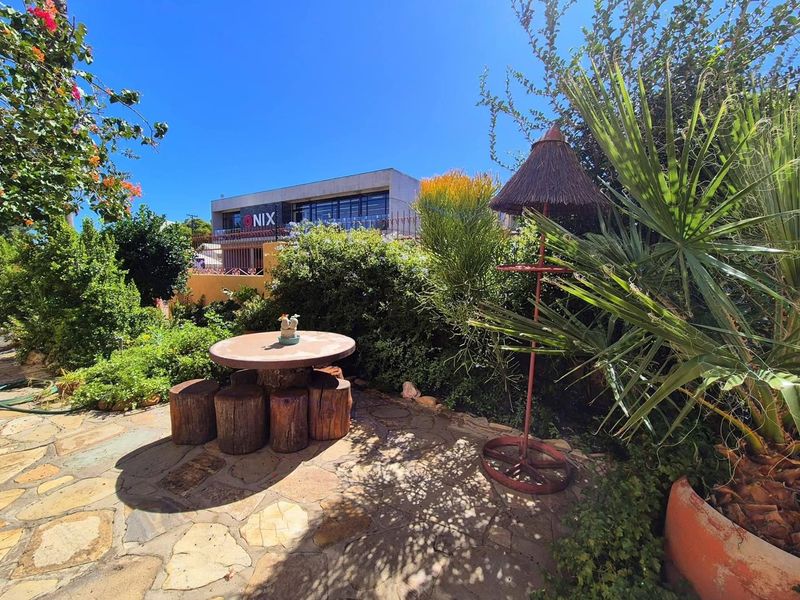 A well-maintained garden area featuring natural stone paving and established landscaping, providing a pleasant outdoor space.