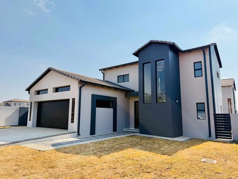 Modern double-story residential home featuring a contemporary facade, tiled roof, and integrated double garage with a paved driveway.