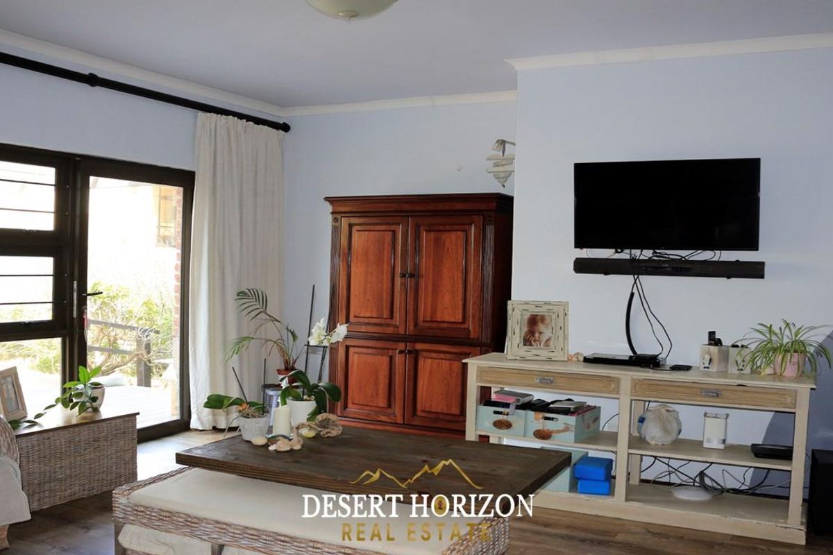A comfortable living room featuring large sliding glass doors that provide natural light and direct access to the outdoor patio area.