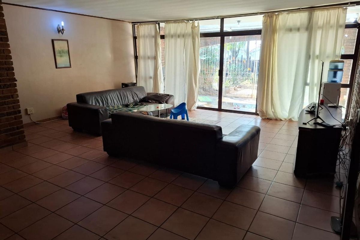 Spacious living room featuring large sliding glass doors that provide natural light and direct access to the outdoor patio area.