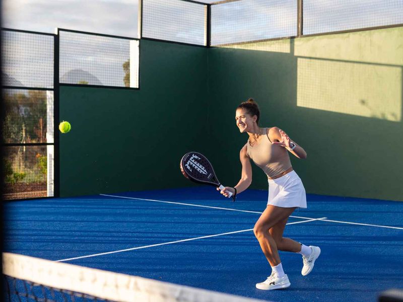 A well-maintained outdoor padel court featuring professional synthetic turf surfacing and secure perimeter fencing.