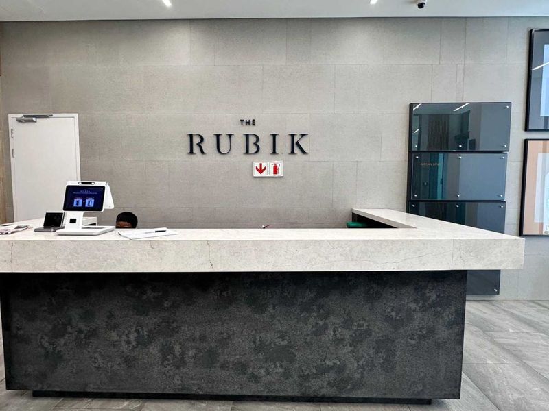 Modern office building reception area featuring a stone-clad feature wall, professional reception desk, and high-quality tiled flooring.