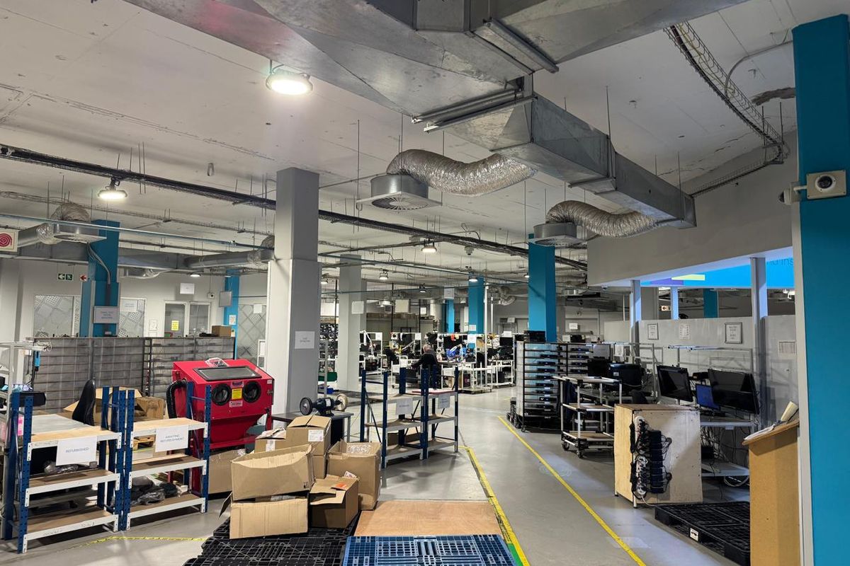 Spacious industrial workshop area featuring exposed ceiling ductwork, concrete flooring, and functional layout suitable for manufacturing or assembly operations.