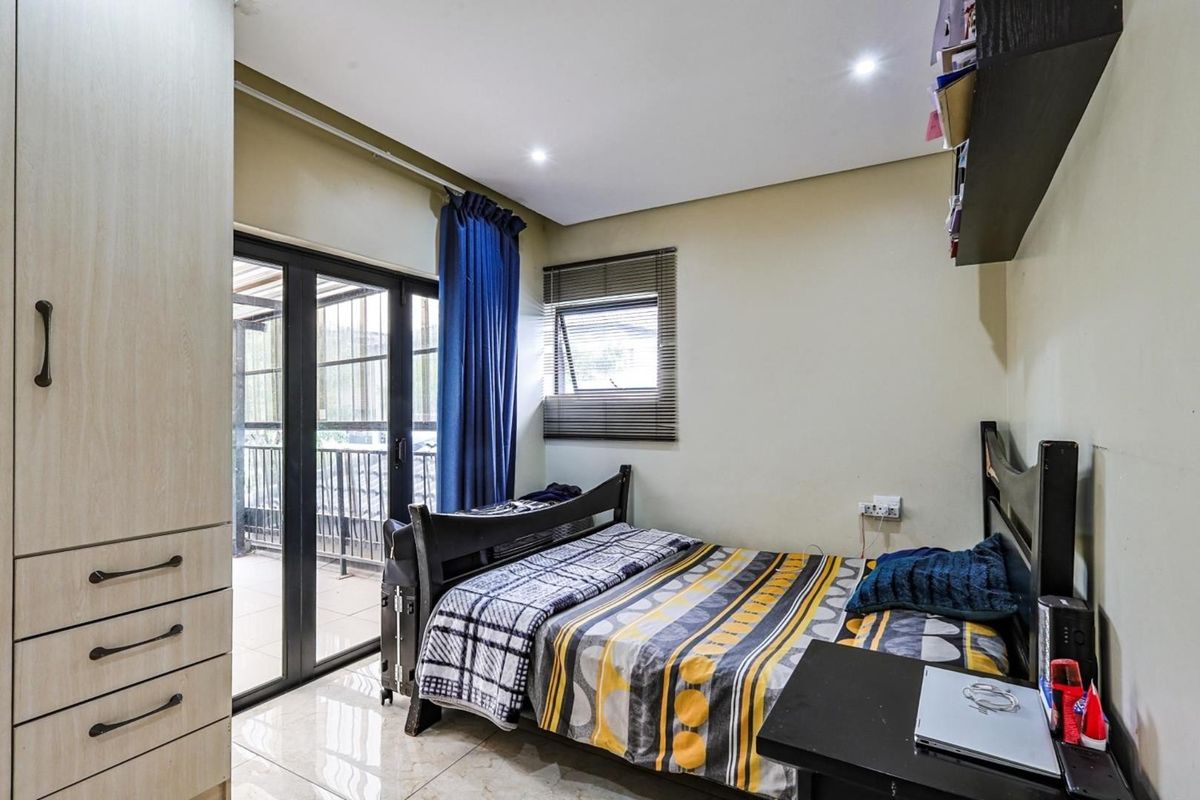 A bedroom featuring tiled flooring, built-in wardrobe storage, and sliding glass doors providing access to an outdoor balcony area.