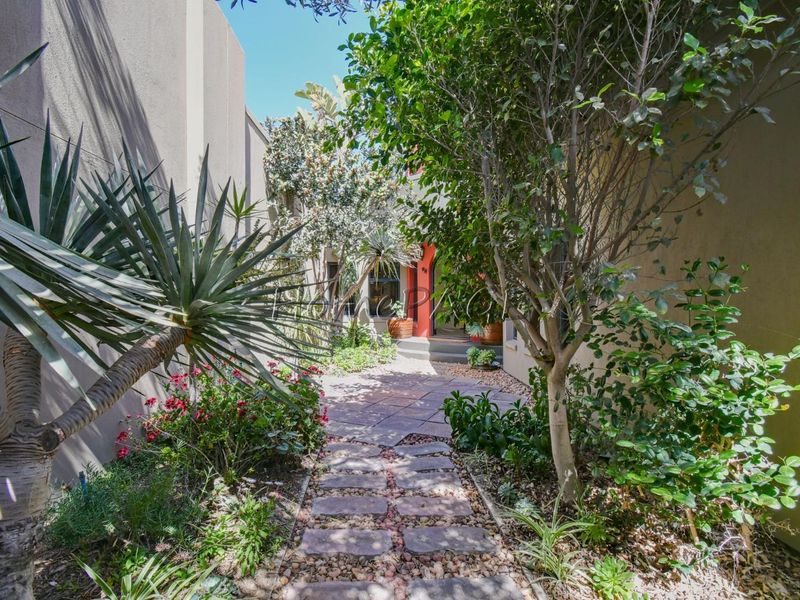 A welcoming front entrance path featuring stone paving and established garden landscaping leading to the main house entry.