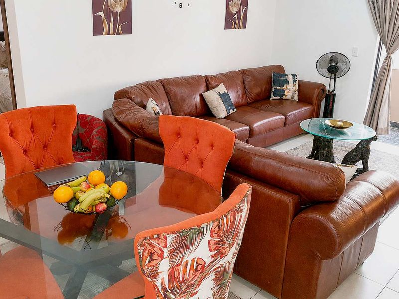 Open-plan living and dining area featuring tiled flooring and direct access to a balcony through a sliding glass door.