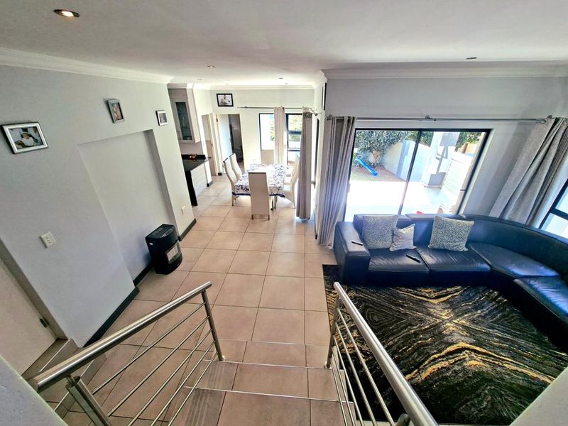 Spacious open-plan living and dining area featuring tiled floors, recessed lighting, and large sliding doors providing seamless access to the outdoor patio.