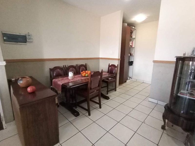 Dining area featuring ceramic tiled flooring, a built-in storage cupboard, and decorative chair rail molding.