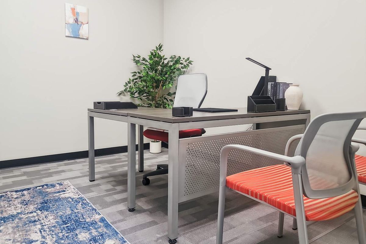 A professional office space featuring neutral wall finishes and durable carpet tile flooring, suitable for a productive work environment.