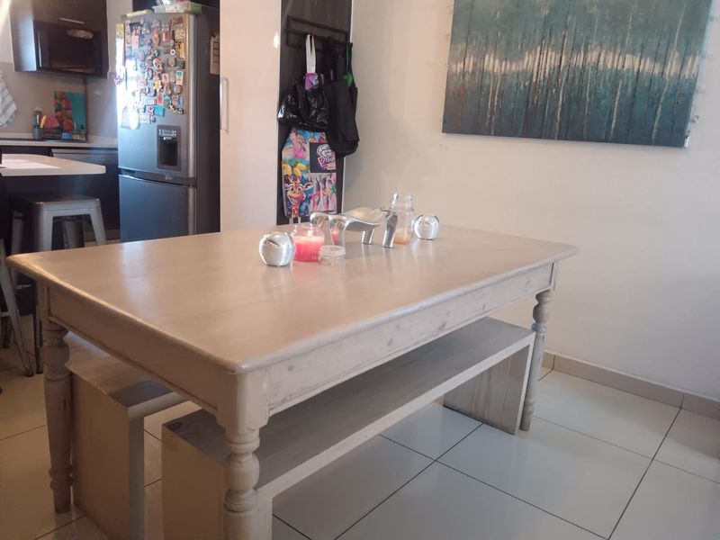 Open plan living and dining area featuring tiled flooring and a view into the adjacent kitchen space.
