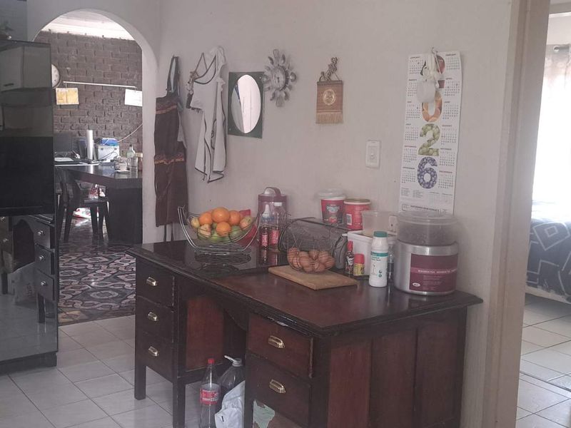A kitchen area featuring tiled flooring and an arched doorway leading to an adjacent living space.