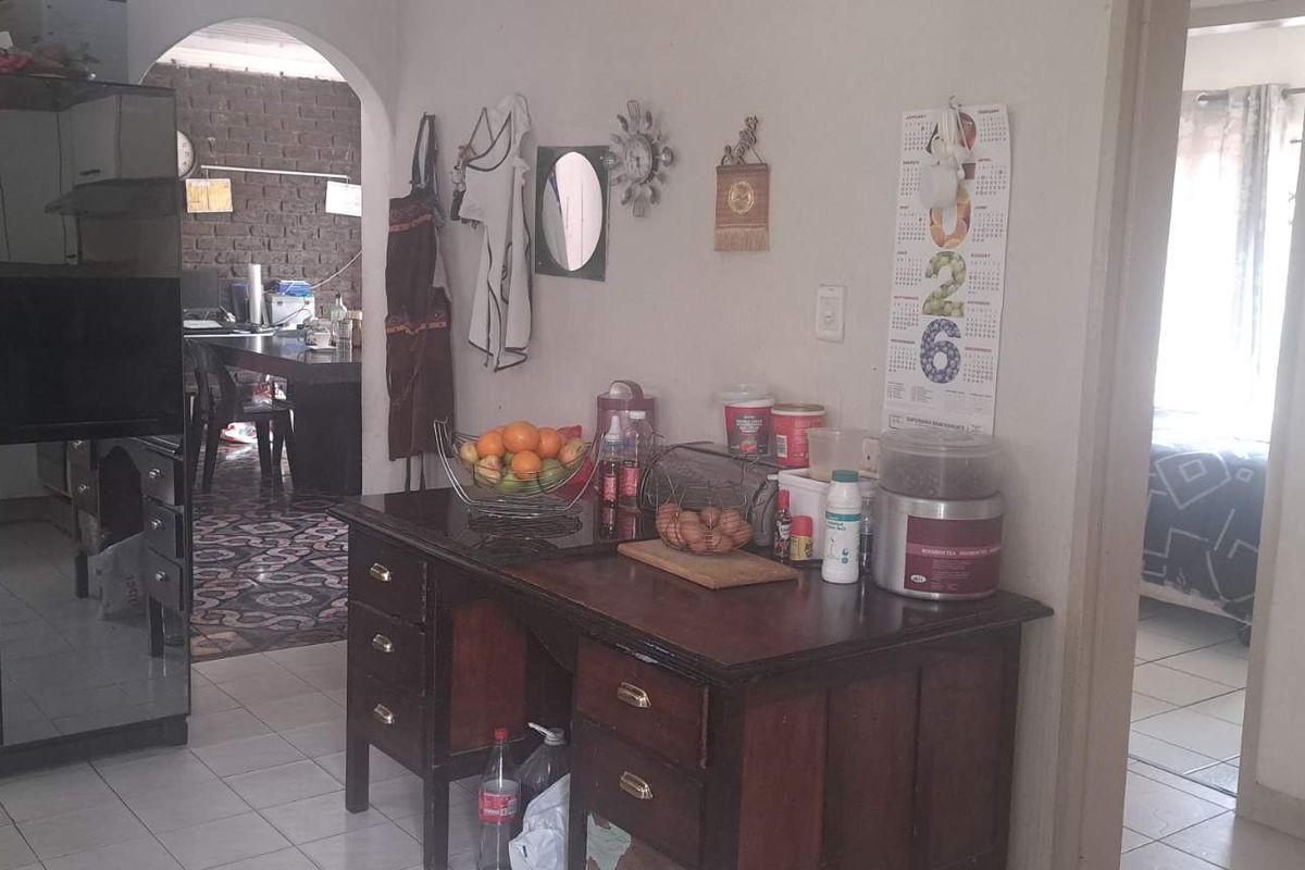 A kitchen area featuring tiled flooring and an arched doorway leading to an adjacent living space.