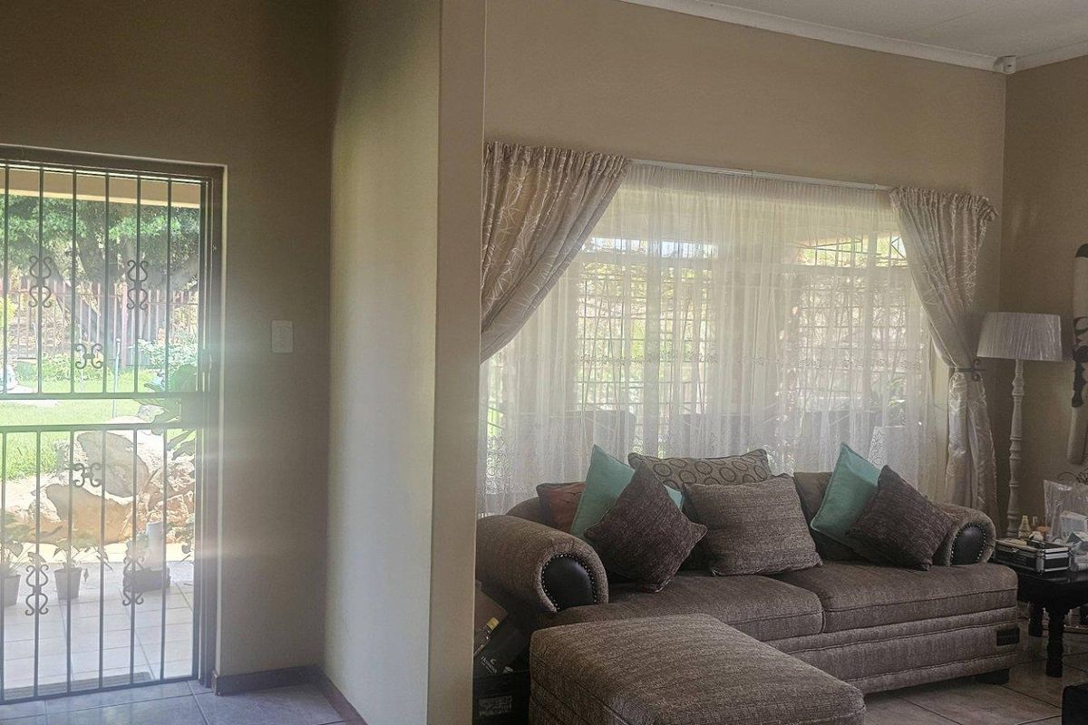 A view of the living room area featuring a security gate at the entrance and large windows allowing natural light into the space.