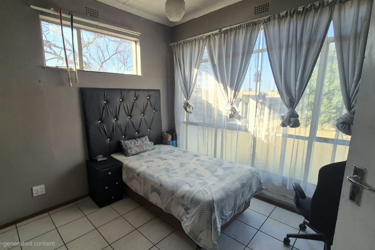 A bedroom featuring tiled flooring and large windows that provide ample natural light, offering a functional space ready for a modern update.