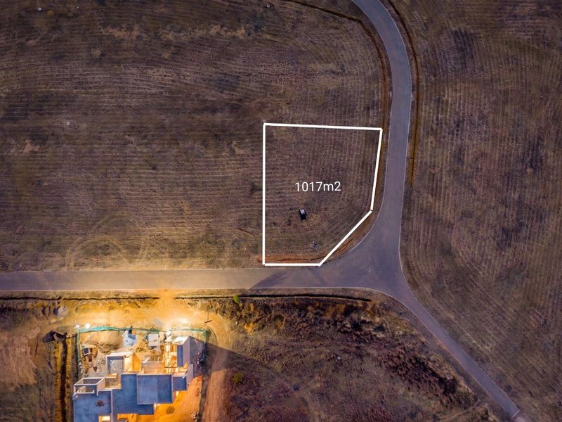 Aerial view of a 1017m2 vacant residential plot with established road access in a developing estate.