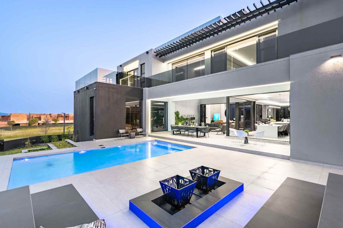 Modern double-story residence featuring a spacious covered patio, swimming pool, and seamless indoor-outdoor flow through large sliding glass doors.