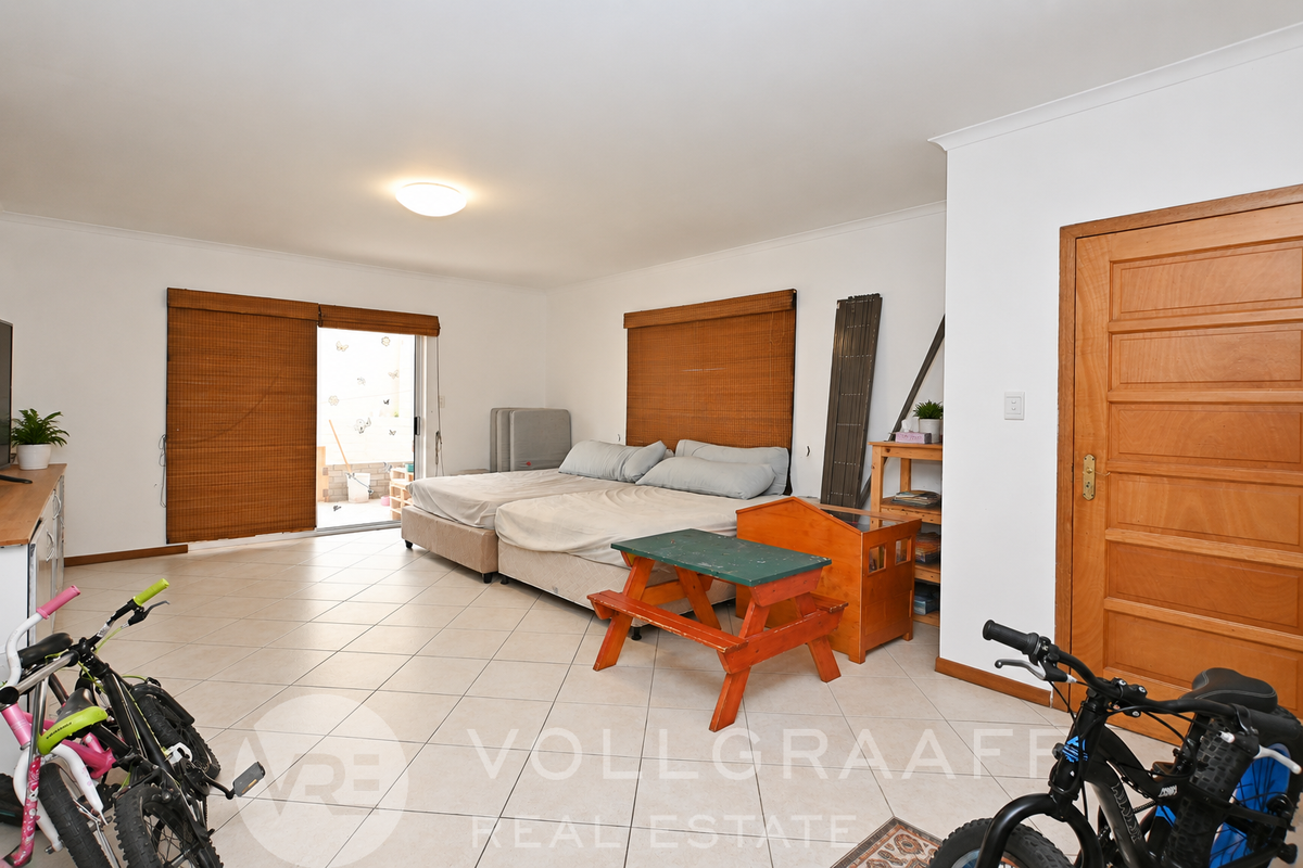 Spacious bedroom featuring tiled flooring, natural light through sliding glass doors, and direct access to an outdoor area.